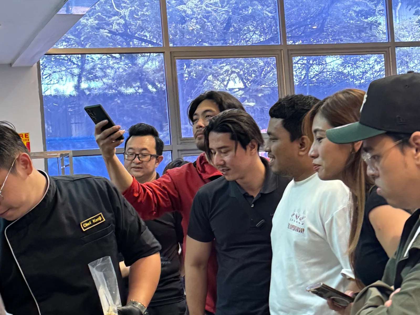 Guests filming a live noodle-cooking demonstration